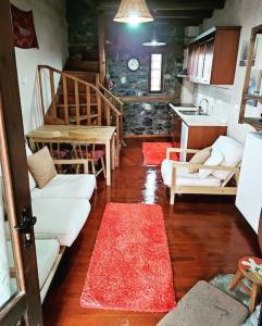 sala de estar con sofás blancos y cocina en Μaisonette Elpida, en Palaios Agios Athanasios