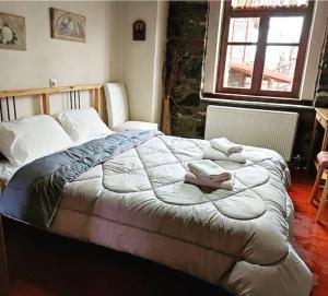 1 dormitorio con 1 cama grande y toallas. en Μaisonette Elpida, en Palaios Agios Athanasios