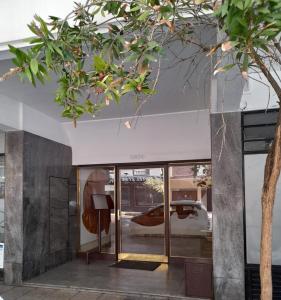 una tienda con puertas de cristal y un árbol en Departamento reciclado a nuevo a 3 cuadras del mar en Mar del Plata