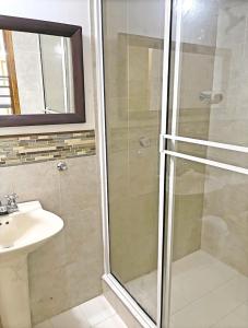 y baño con ducha y lavamanos. en Espectacular Apartamento con Vista al Mar en San Andrés