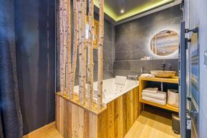 a bathroom with a tub and a sink at Appartement style chalet 5* vue Mont-Blanc - Arc 1950 in Arc 1950