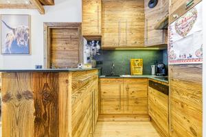 kuchnia z drewnianymi szafkami i krową na ścianie w obiekcie Appartement style chalet 5* vue Mont-Blanc - Arc 1950 w mieście Arc 1950 +16 zdjęć