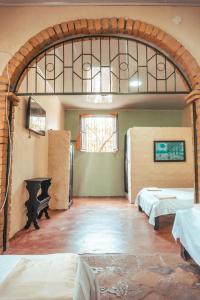 a room with two beds and an arched doorway at Casa Colonial in Mariquita