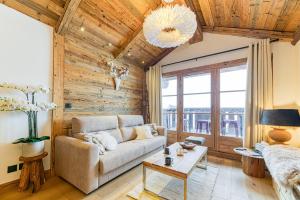 a living room with a couch and a table at Appartement style chalet 5* vue Mont-Blanc - Arc 1950 in Arc 1950