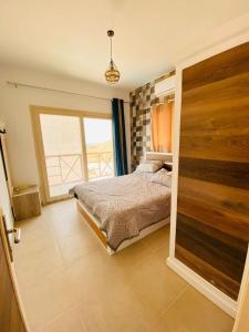 a bedroom with a bed and a large window at Dahab Hills Villa and Studios in Dahab
