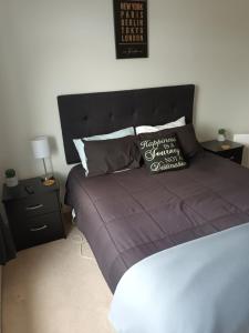un letto con piumone viola e cuscino sopra di Ahaura Hotel a Greymouth