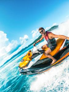 Un uomo che cavalca una moto d'acqua di Palm Bungalows a Hamilton Island