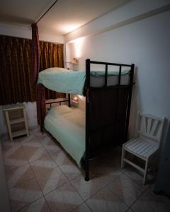 una piccola camera con letto a castello e sedia di Mama Backpackers a Lima