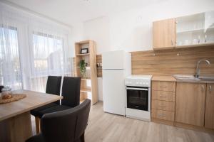 a kitchen with a white refrigerator and a table at Apartman Mirna Vinkovci in Vinkovci