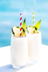due bicchieri di cocktail di mele con cannucce a righe rosse e bianche di Beach Club a Hamilton Island
