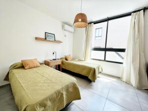 une chambre avec deux lits et une fenêtre dans l'établissement PASEO QUATTRO, à Villa Carlos Paz 269 autres photos