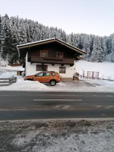 un coche naranja estacionado frente a una casa en Haus Spertental, en Kirchberg in Tirol