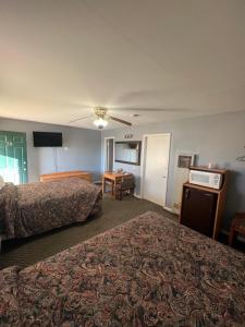 a hotel room with two beds and a television at Western Motel in Sayre