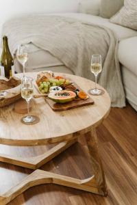 uma mesa com um prato de comida e dois copos de vinho em Shearwater em Culburra Beach