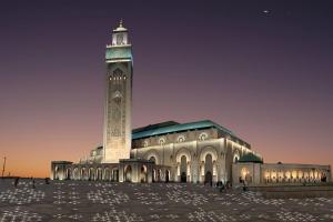 a large building with a clock tower at night at appartement centre in Casablanca