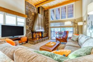 sala de estar con sofá, TV y chimenea en Wildflower Condos #11, en Sunriver