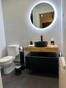 a bathroom with a sink and a toilet and a mirror at Salabardoa Ea in Ea +19 photos