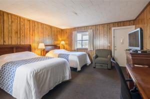 a hotel room with two beds and a flat screen tv at Knob Hill Motor Lodge in Hillsville