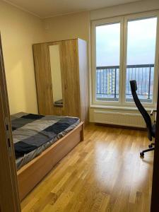 Schlafzimmer mit einem Bett, einem Schreibtisch und Fenstern in der Unterkunft Belgrade Balcony in Belgrad