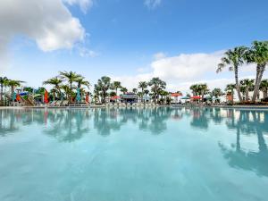 a large swimming pool with palm trees in the background at Windsor Island Vacation Pool Home in Davenport