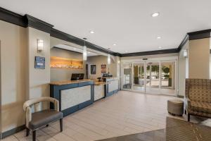 a lobby of a hotel with a counter and chairs at Best Western South Plains Inn & Suites in Levelland