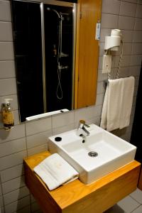 y baño con lavabo blanco y espejo. en Paredes Hotel Apartamento en Paredes