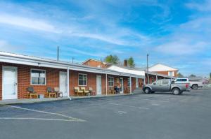 a car parked in a parking lot in front of a building at Knob Hill Motor Lodge in Hillsville