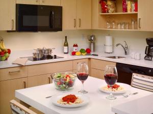 a kitchen with two glasses of wine and a bowl of food at Avia Residences on Lincoln - Extended Stay in Malvern