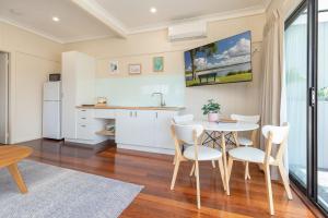 a kitchen and dining room with a table and chairs at Jasmine Apartment in Forster
