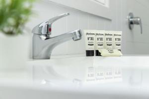 a bathroom sink with a faucet and a sign on a counter at Jasmine Apartment in Forster