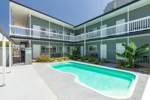 a swimming pool in front of a building at Jasmine Apartment in Forster