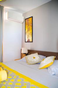 - une chambre avec un lit doté d'oreillers jaunes et blancs dans l'établissement Studio Karukera Love, à Saint-François