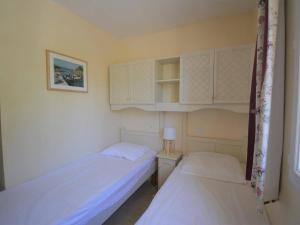 two beds in a small room with white cabinets at Maison 6 pers. avec Terrasse Privée, 3 Pièces en Duplex – Wifi & Animaux Admis - FR-1-382-119 in Grospierres