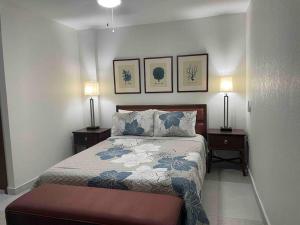 Koolbaai1 bedroom apt with pool in Simpson Bay的一间卧室配有一张床、两个床头柜和两盏灯。