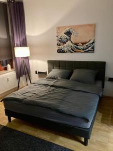 Bett in einem Schlafzimmer mit Wandgemälde in der Unterkunft Cozy Studio-Apartment - Südplatz in Leipzig