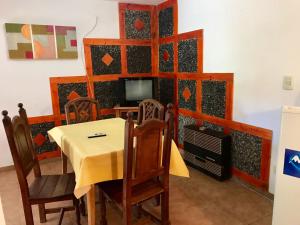 comedor con mesa, sillas y TV en departamentos pama en Santa Rosa de Calamuchita