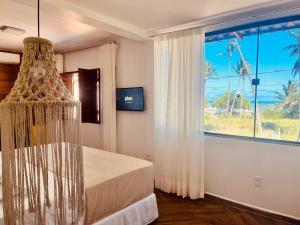 a bedroom with a bed and a large window at Pousada Iandê Patacho in Pôrto de Pedras +74 photos