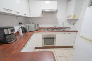een keuken met witte kasten en een aanrechtblad bij La Serena - Departamento Frente al Mar in La Serena