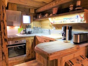 a large kitchen with wooden cabinets and a stove at Chalet cosy 3-4 pers, idéalement situé, à 500m des pistes et 100m des commerces - FR-1-342-220 in Beaufort