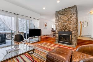 a living room with a large stone fireplace at Mansfield View Memories in Stowe