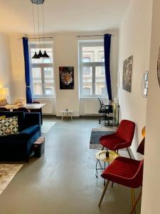 a living room with red chairs and a blue couch at Sehr Zentrale Wohnung-Loftstyle- in Vienna