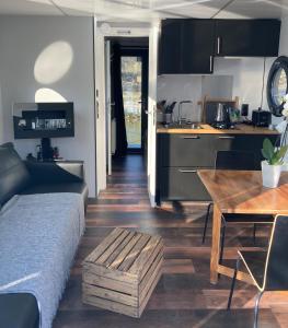a kitchen and living room with a bed and a table at Ecolodge Charles Ashton Hébergement insolite sur l'eau in Sarzeau