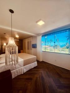 - une chambre avec un lit et une grande fenêtre dans l'établissement Pousada Iandê Patacho, à Porto de Pedras