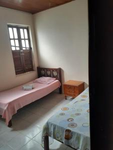 een slaapkamer met 2 bedden en een raam bij Casa de Lençóis in Lençóis