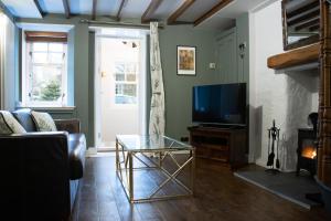 a living room with a tv and a glass coffee table at The Burrow in Kelso