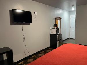 Zimmer mit einem Flachbild-TV an der Wand in der Unterkunft Midway Motel 