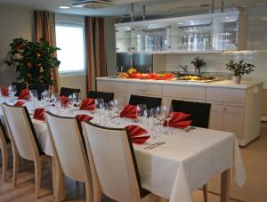 a dining room with a table with red napkins and wine glasses at Tanhuvaara Sport Resort in Savonlinna