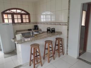 a kitchen with two bar stools and a counter at Recanto de Araruama in Araruama