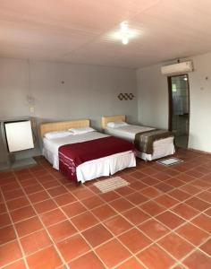貝貝里比的住宿－Recreio das Fontes，一间带两张床的卧室,铺有瓷砖地板。