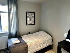 um pequeno quarto com uma cama e uma janela em Elegant apartment in Keflavík em Keflavík